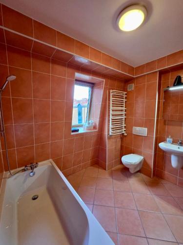 a bathroom with a tub and a toilet and a sink at Justinrent Szpitalna 4D-5 in Legnica