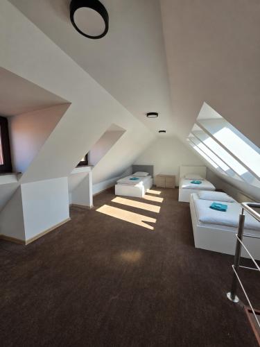 a attic room with three beds and a window at Justinrent Szpitalna 4D-5 in Legnica