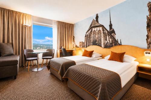 a hotel room with two beds and a table at Cosmopolitan Bobycentrum - Czech Leading Hotels in Brno