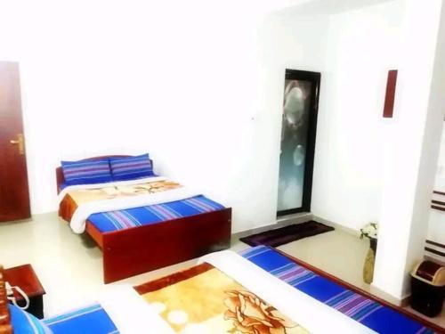 a bedroom with a bed with blue and white sheets at Breeze Mahagedara in Nuwara Eliya