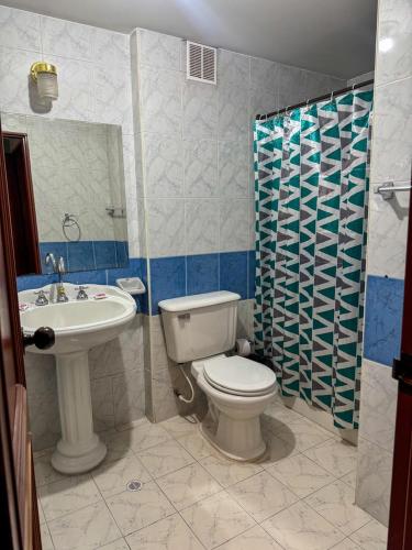 a bathroom with a toilet and a sink and a shower at HOTEL REALPICO VICTORIA in Duitama