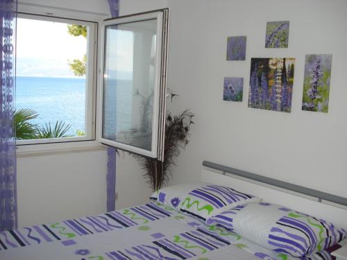 a bedroom with a bed and a window with the ocean at Sea Star Apartment in Sutivan