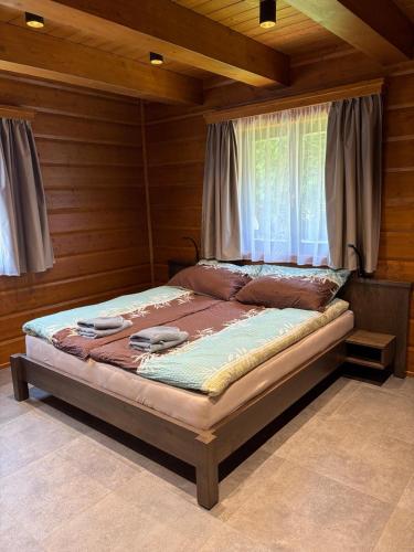 a bed sitting in a room with a window at Chalupa Nicol in Vítějeves