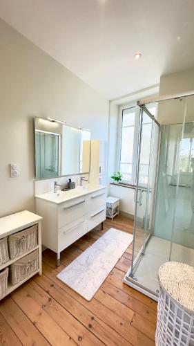 a bathroom with a sink and a glass shower at Le Quai Granvillais in Granville