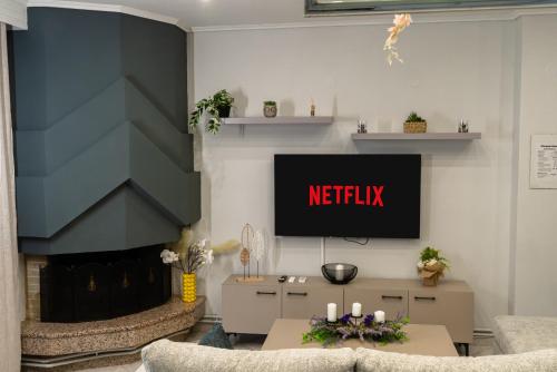 a living room with a tv and a fireplace at Elissavet Maison in Perea