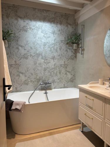 a bathroom with a bath tub and a sink at Clos Lavaux in Châtenay