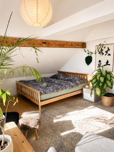 a bed in a room with plants at Old Farmhouse Loft near Vaduz in Sevelen