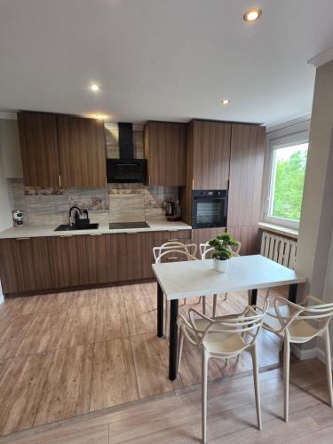 a kitchen with a table and chairs and a counter at Apartament dla 7 osób in Głogów