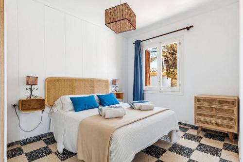 a bedroom with a bed with blue pillows on it at Las Belisas in Arenal d'en Castell