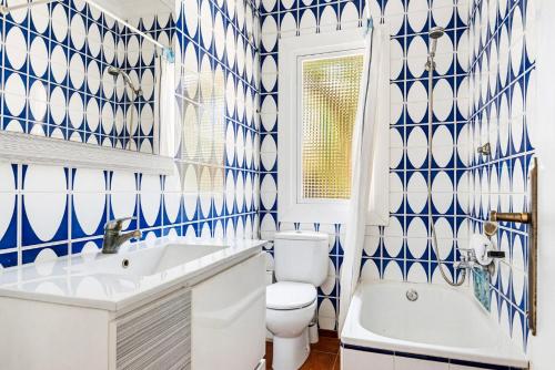 a blue and white bathroom with a toilet and a sink at Las Belisas in Arenal d'en Castell