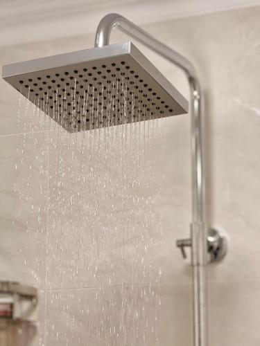 a shower head with water coming out of it at Уютный дом GS in Kegeti