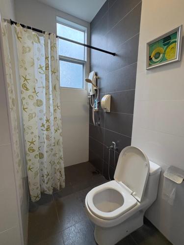 a bathroom with a toilet and a shower curtain at Art Villa in Alor Setar