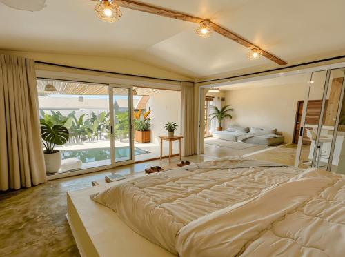 a large bedroom with a large bed and a living room at Thara Coco Villa - Boutique Luxury In Srithanu in Hinkong