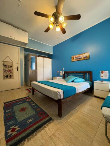 a blue bedroom with a bed with a ceiling fan at Florence Chalet in Marina Wadi Degla Ain Sokhna - Ground floor with 360 Sqm with Private Garden in Ain Sokhna