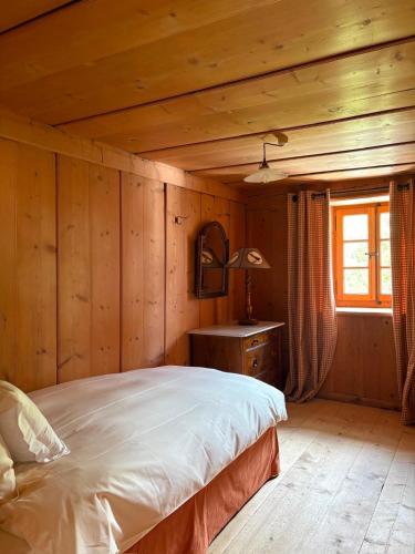 a bedroom with a bed in a room with wooden walls at Chalet de montagne sur le TMB in La Fouly