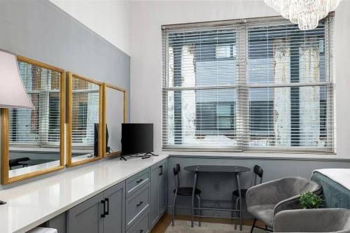 a room with a desk with a table and two windows at Stylish Birmingham Loft + Rooftop Lounge in Birmingham