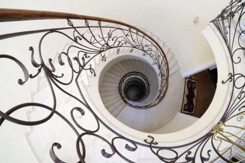 a spiral staircase with wrought iron railings at S&L Boutique Hotel in Tbilisi City