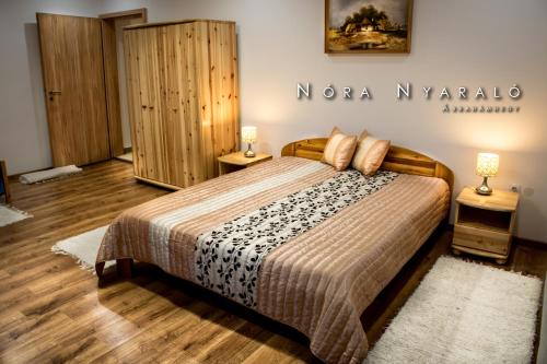 a bedroom with a bed and two night stands at Nóra Wellness nyaraló in Ábrahámhegy