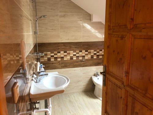 a bathroom with a sink and a toilet at Nóra Wellness nyaraló in Ábrahámhegy