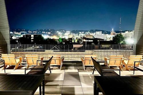 a balcony with tables and chairs and a view of a city at Stylish Birmingham Loft + Rooftop Lounge in Birmingham