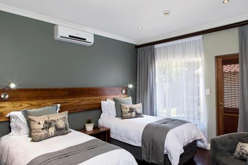 a hotel room with two beds and a chair at 178 Club in Pretoria