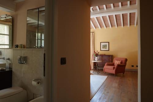a bathroom with a red chair and a living room at Villa Valle, Villa Saletta Wine Estate in Forcoli