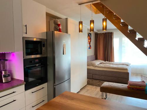 a kitchen with a stainless steel refrigerator and a bedroom at Garden Spa Resort in Budapest