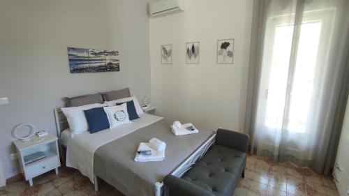 a bedroom with a bed and a chair with towels on it at CAPERCIA home in Forio d'Ischia