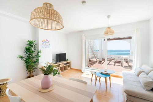 a living room with a table and a view of the ocean at MarLau Breeze in Mojácar