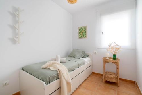 a small bedroom with a bed and a table at MarLau Breeze in Mojácar