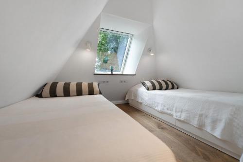 two beds in a room with a window at Reetdachkate in Esgrus