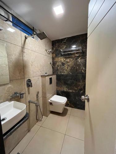 a bathroom with a toilet and a sink and a shower at Hotel LIORA GRAND in Bangalore