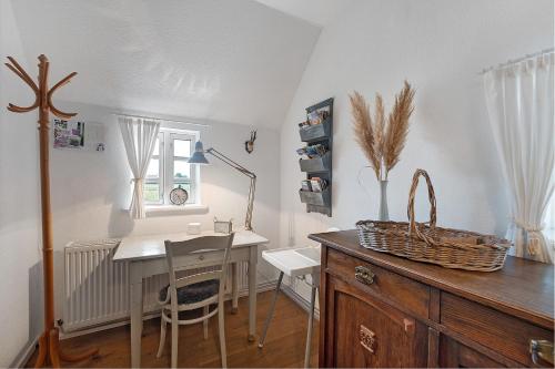 a room with a desk and a table with chairs at Reetdachkate in Esgrus