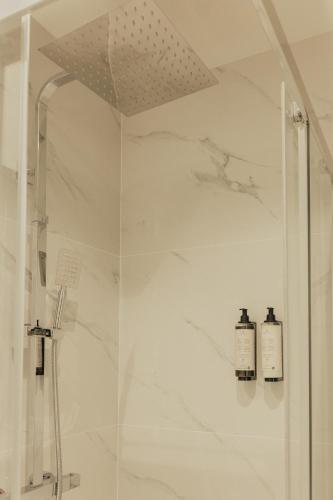 a bathroom with a shower with two soap bottles at Gerês Thermal Escape in Geres
