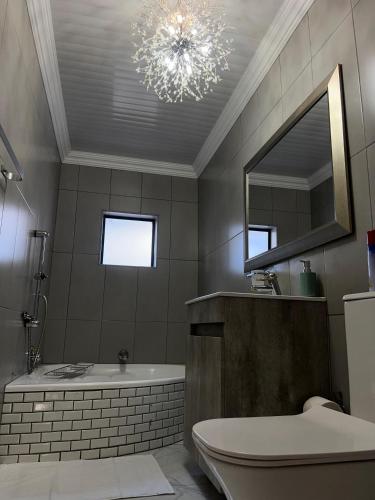 a bathroom with a bath tub and a chandelier at Kariebi Guest House in Bethlehem