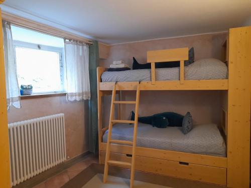 two bunk beds in a small room with a window at Di Baut in Ovaro