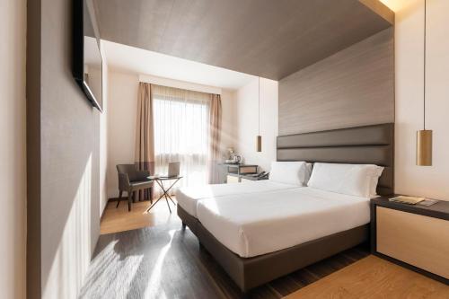 ein Hotelzimmer mit Bett und Schreibtisch in der Unterkunft Warmthotel in Rom