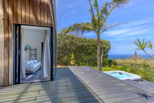 a room with a view of the ocean from a wooden deck at GuestReady - Casa do Horizonte in Mosteiros