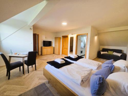 a bedroom with two beds and a table and a couch at Weingut Primus Südsteiermark in Spielfeld