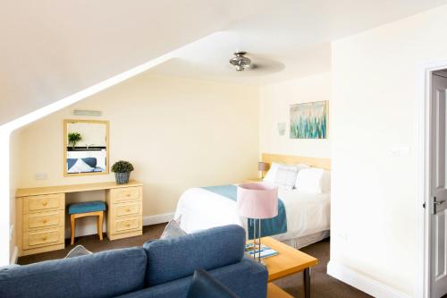 a bedroom with a bed and a blue couch at SACO Jersey - Merlin House in Saint Helier Jersey
