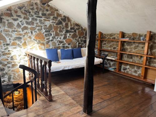 a couch in a room with a stone wall at Casa de Aldea EL Fusu in Taranes