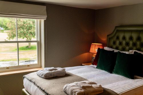 a bedroom with a bed with two towels on it at The Norman Knight in Whichford