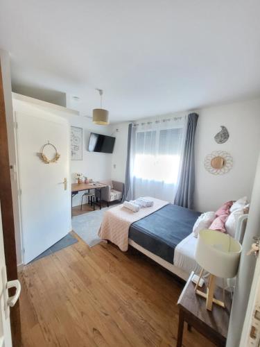 a bedroom with a bed and a desk in it at "Les Logis d'Argent Mimizan Chambre d'hôte climatisée avec WC, SDB, TV, Wifi, Option Petit Déjeuner , Parking in Mimizan