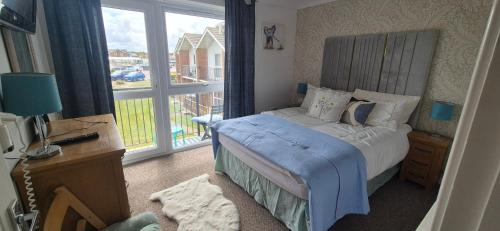 a bedroom with a bed and a large window at The cosy house in Corton