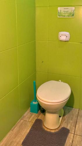 a bathroom with a toilet in a green wall at Apartamento próximo ao centro in Primavera do Leste