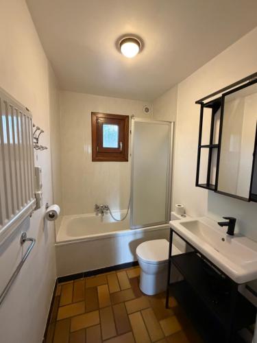 a bathroom with a tub and a toilet and a sink at Cabana 16 in Petit Mesnil