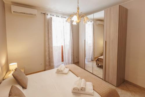 a bedroom with a mirror and a bed with white towels at Casa Lina - 10 minuti da Pantalica-parcheggio gratuito in Sortino