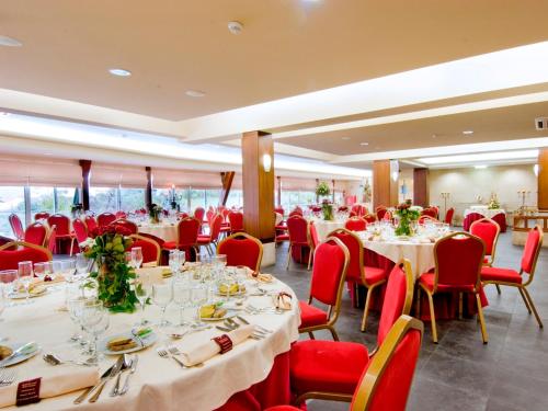 a dining room with tables and red chairs at Hotel Eurosol Seia Camelo in Seia