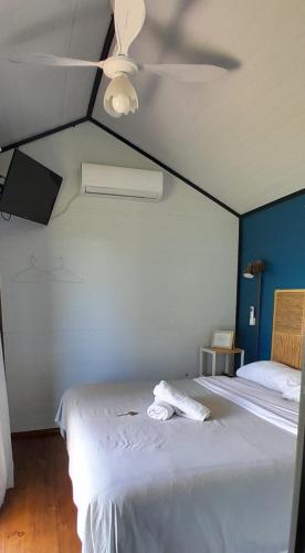 a bedroom with a white bed with a ceiling fan at Cantal Tiny Houses in Salta