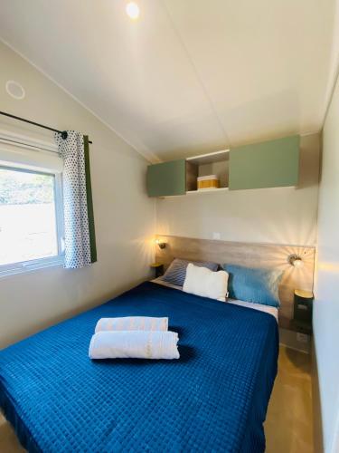 a bedroom with a blue bed with two pillows at Premium Sea View in Saint-Raphaël